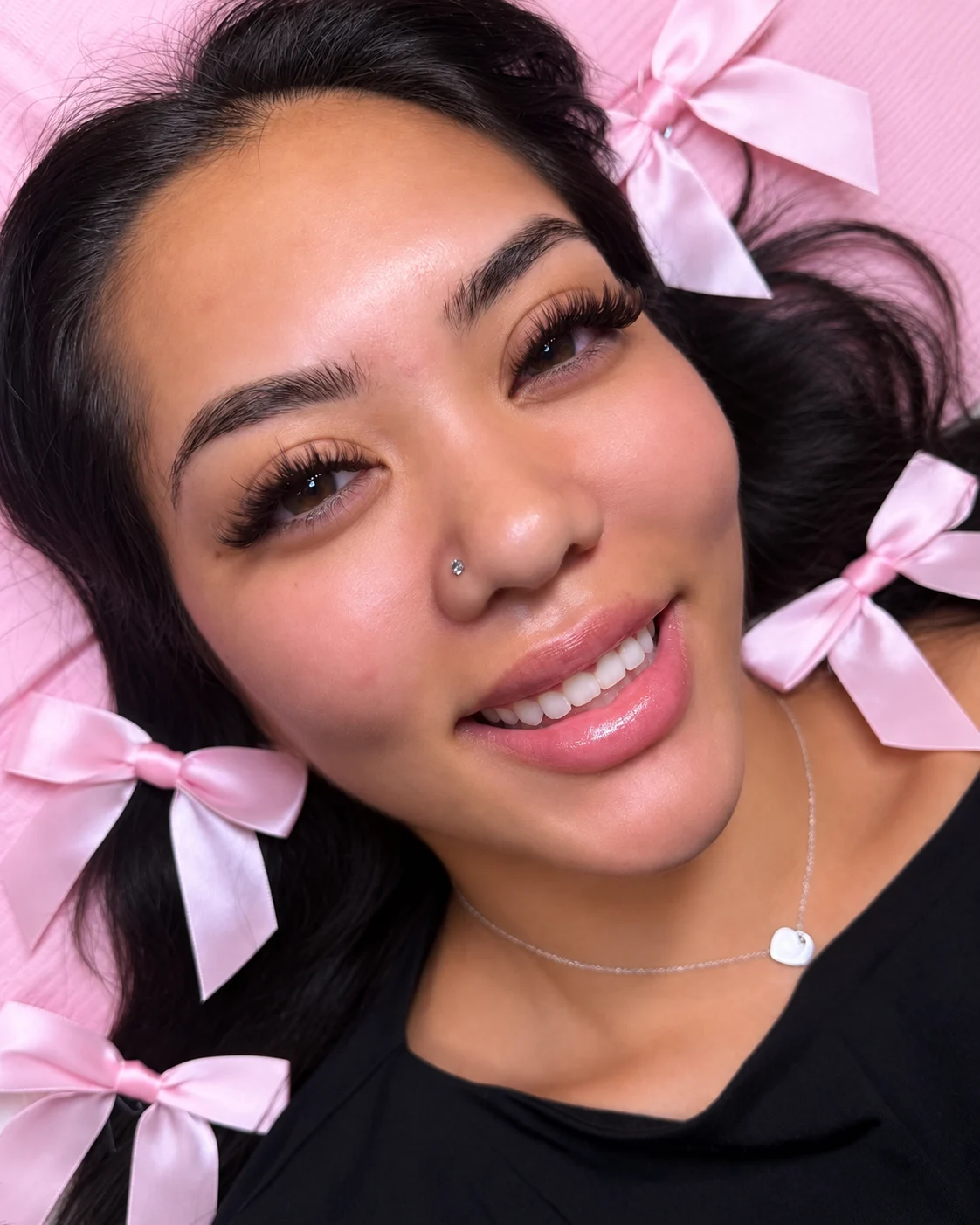 Client with long lash extensions and pink bows in her hair